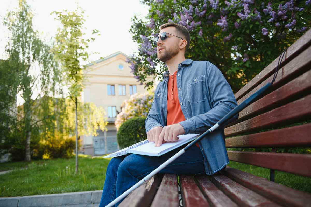 Blind man reading in the park